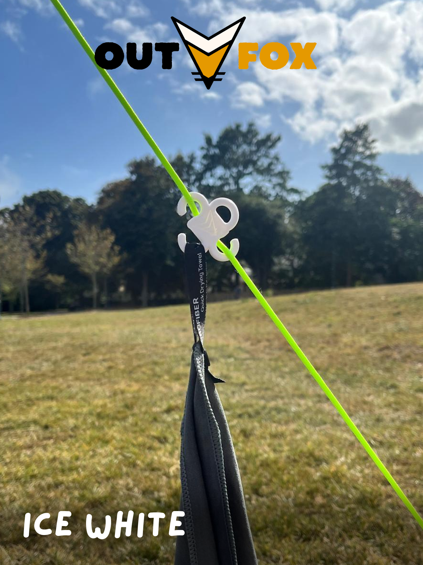 Plastic guy line hook, in Ice White, holding a towel in nature, with Outfox branding.